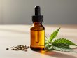 Amber glass dropper bottle of hemp-derived CBD oil with golden liquid, surrounded by hemp seeds and green hemp leaves on a wooden surface