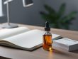 “CBD oil dropper bottle next to an open notebook and medical-style reference cards, suggesting an educational benefits chart concept.”